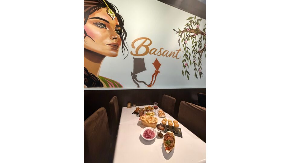 Basant mural of a woman with food laid out on a table in front