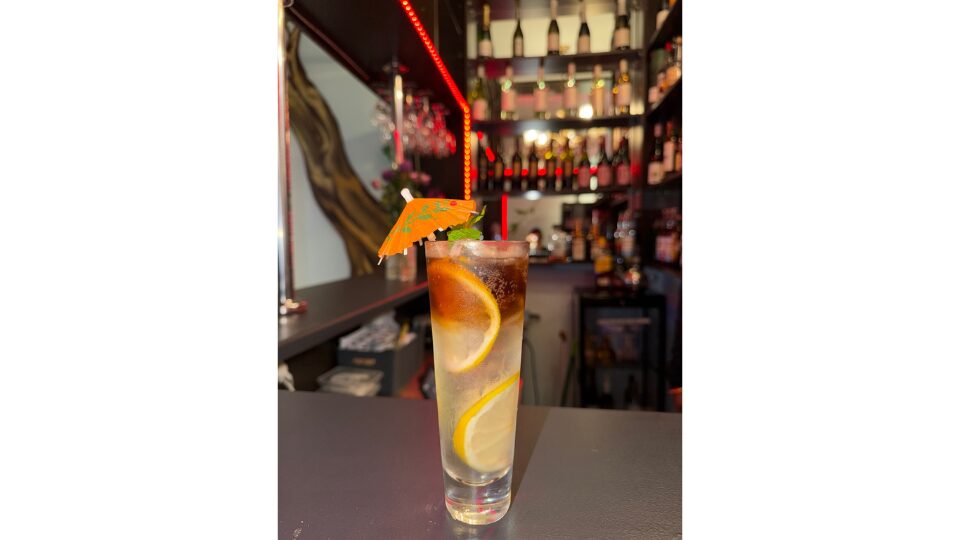 Tropical drink with a bar in the background