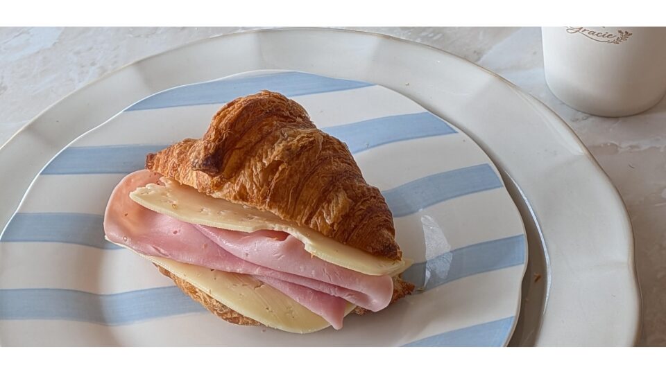 Croissant with ham and cheese on a plate