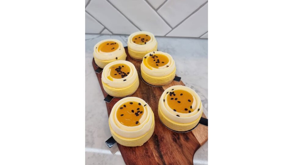 Small fruit cheesecakes on a wooden chopping board