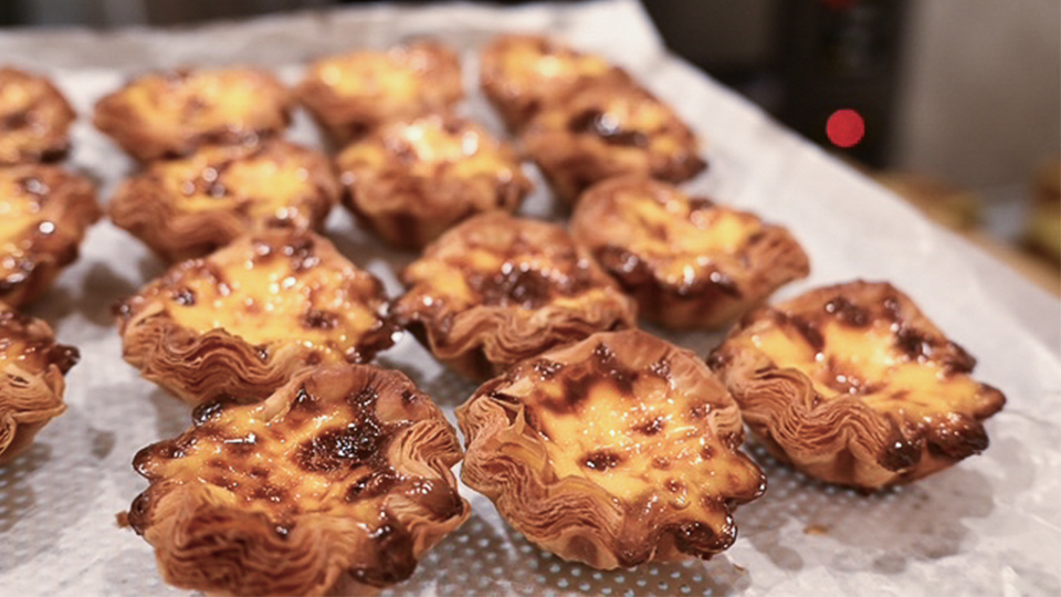 Close up of a tray of freshly baked portuguese egg tarts.